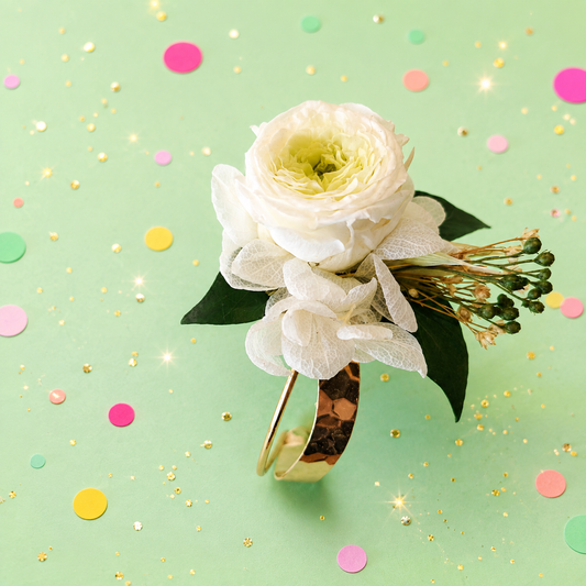 Bracelet jonc martele dore avec rose et hortensia stabilises blanc ivoire et feuillage vert pour mariage