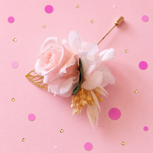 Boutonniere mariage premium avec rose stabilisee rose poudre hortensia blanc et feuille doree