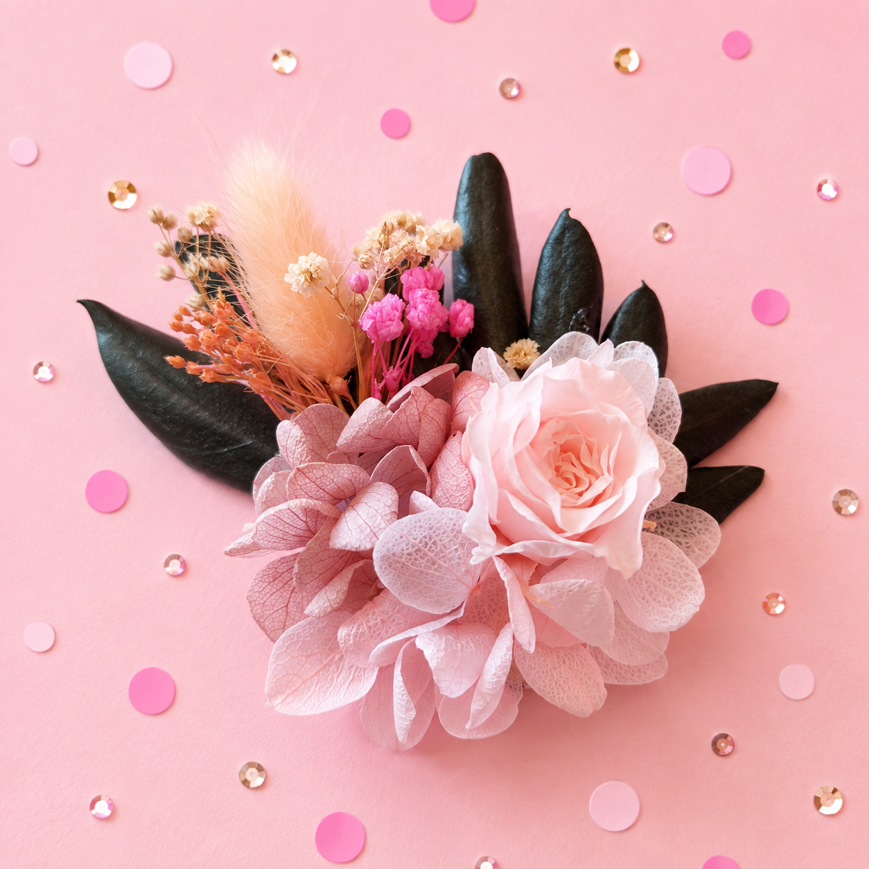 Boutonniere badge broche fleurs stabilisees rose poudre peche fuchsia et feuillage vert sombre pour mariage