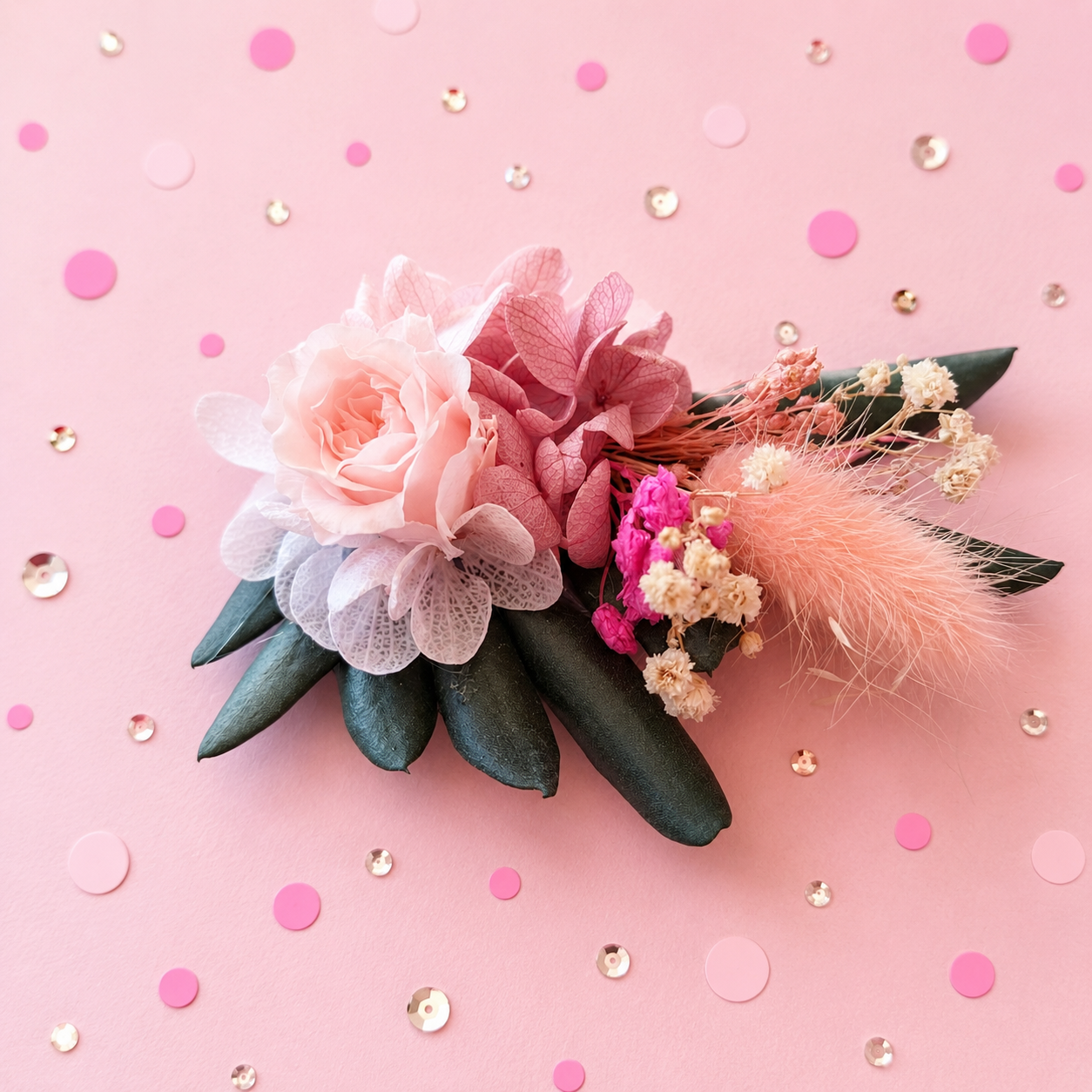 Boutonniere badge broche fleurs stabilisees rose poudre peche fuchsia et feuillage vert sombre pour mariage